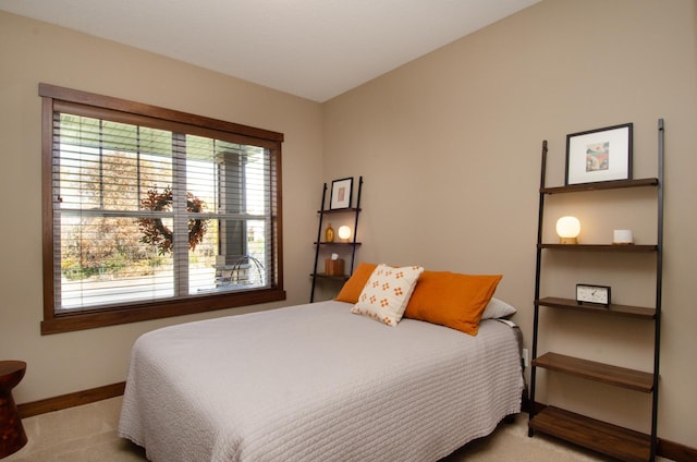 bedroom featuring light carpet and baseboards