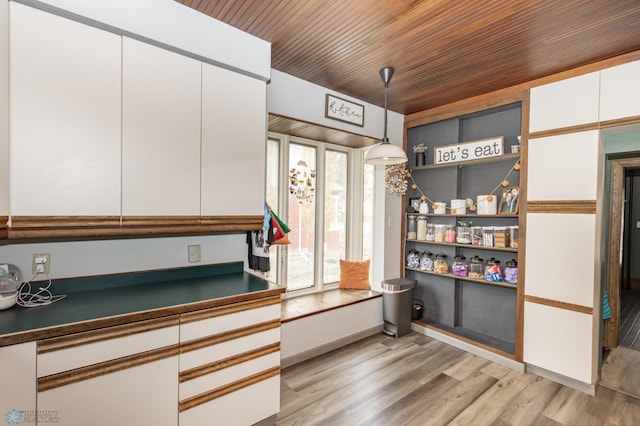 kitchen with light hardwood / wood-style floors, wood ceiling, white cabinets, and hanging light fixtures