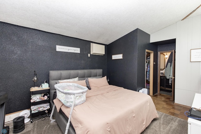 bedroom with a closet, a textured ceiling, lofted ceiling, and a walk in closet