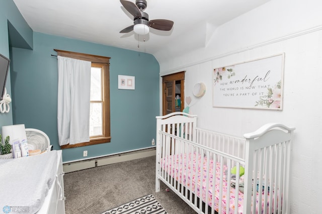 carpeted bedroom with baseboard heating, lofted ceiling, a nursery area, and ceiling fan