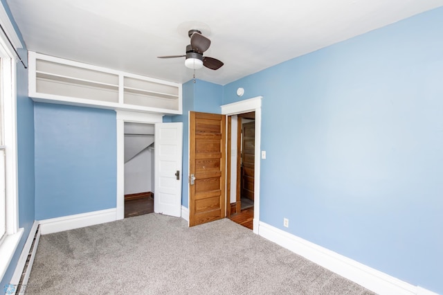 807 4th St S, Moorhead, MN 56560 - unfurnished bedroom with carpet flooring, a closet, a baseboard heating unit, baseboards, and a ceiling fan
