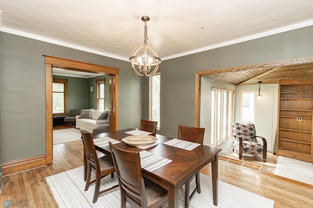 807 4th St S, Moorhead, MN 56560 - dining space featuring light wood-style floors, a chandelier, crown molding, radiator, and baseboards