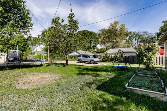 807 4th St S, Moorhead, MN 56560 - view of yard featuring a trampoline and a vegetable garden