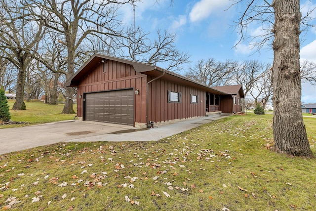 view of side of home featuring a garage and a lawn