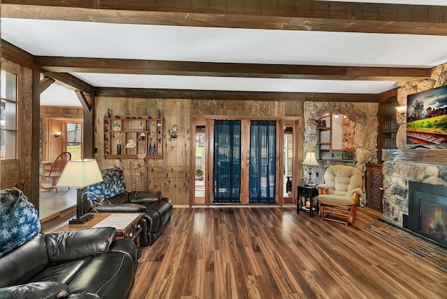 unfurnished living room featuring a fireplace, wooden walls, beamed ceiling, and dark hardwood / wood-style flooring