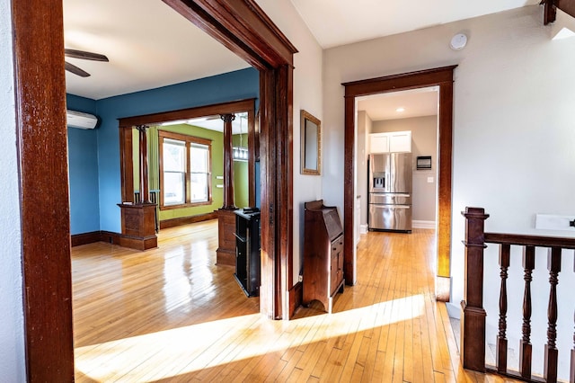 hallway with light hardwood / wood-style floors and a wall unit AC