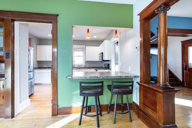 kitchen with white cabinets, stainless steel appliances, and light wood-type flooring