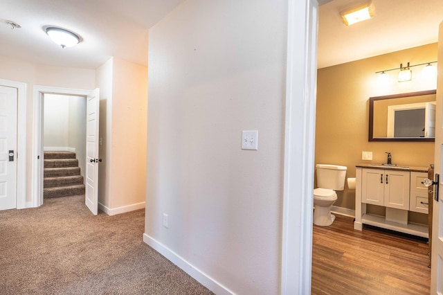 hall with light hardwood / wood-style flooring and sink