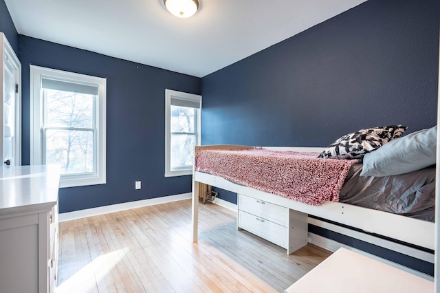 bedroom with light hardwood / wood-style flooring and multiple windows