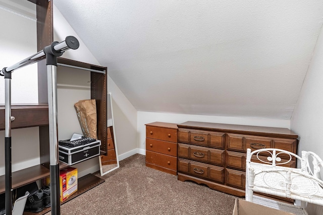 carpeted bedroom featuring a textured ceiling and vaulted ceiling