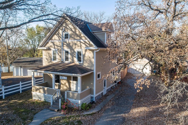 view of side of property featuring an outdoor structure, a garage, and a porch