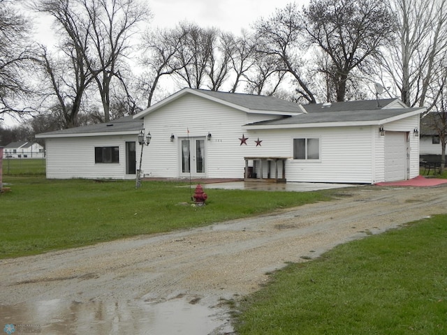 back of property featuring a yard and a garage