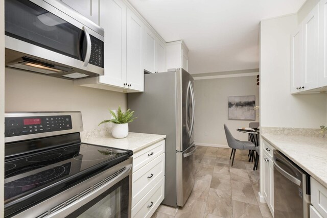 kitchen featuring light stone countertops, appliances with stainless steel finishes, and white cabinets