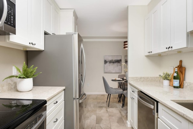 kitchen featuring white cabinets, light stone counters, and stainless steel appliances