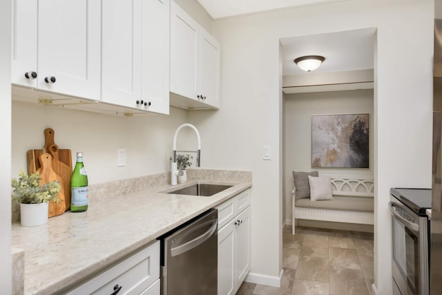 kitchen featuring white cabinets, sink, light stone counters, and stainless steel appliances