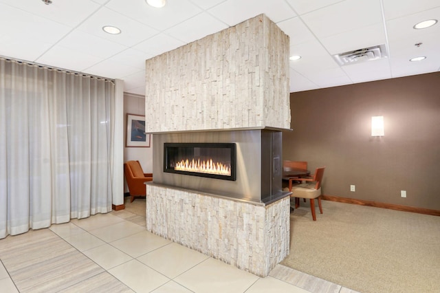 tiled living room featuring a paneled ceiling