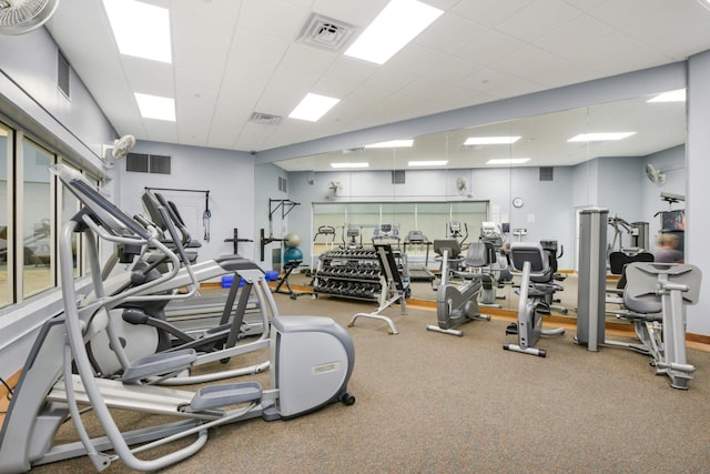 gym with a drop ceiling and plenty of natural light