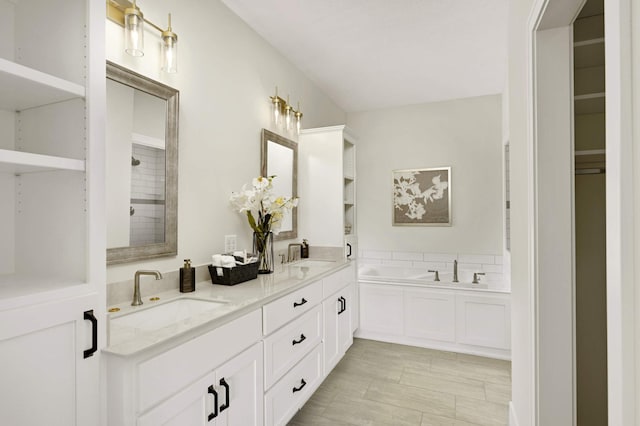 bathroom with vanity and a bath