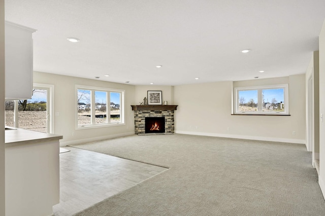 unfurnished living room with a fireplace and light colored carpet