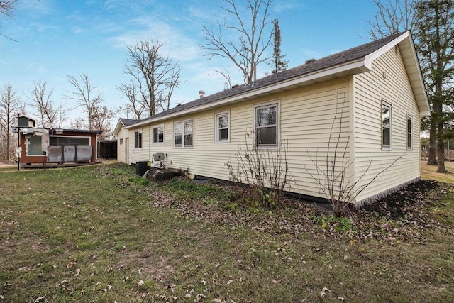 rear view of house featuring a yard and a sunroom