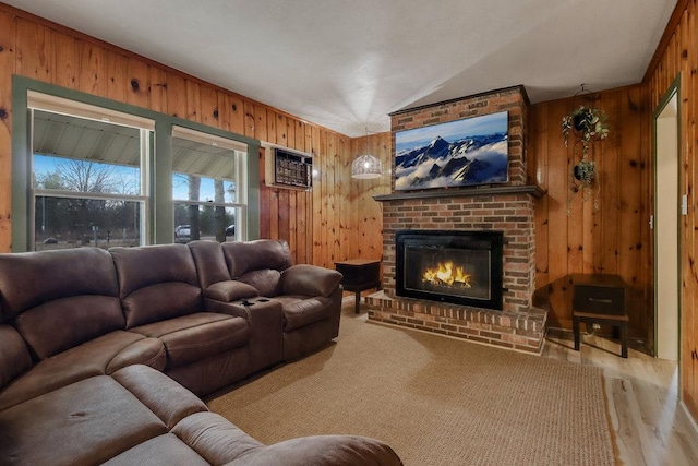 living room with a fireplace, a wall mounted AC, light hardwood / wood-style flooring, and wood walls