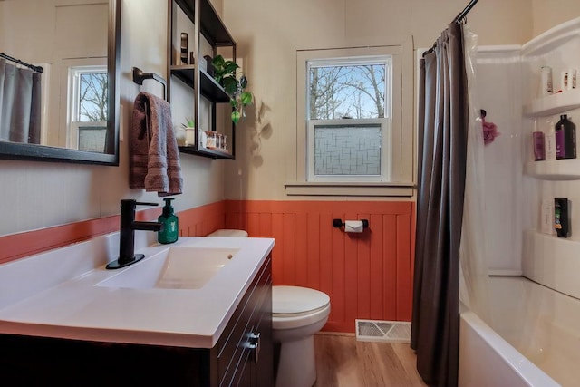 full bathroom with vanity, toilet, shower / bath combo with shower curtain, and a wealth of natural light