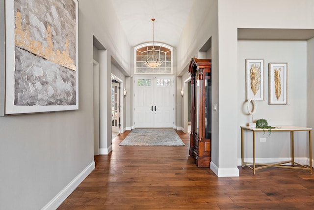 foyer entrance with vaulted ceiling, a chandelier, and dark hardwood / wood-style floors