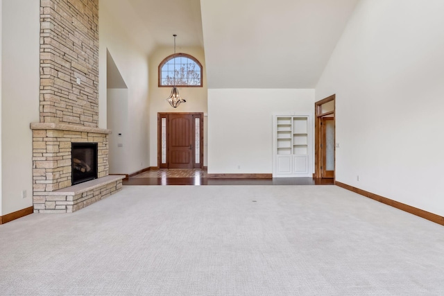 unfurnished living room with carpet floors, a stone fireplace, and high vaulted ceiling