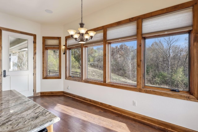 unfurnished sunroom featuring plenty of natural light and a chandelier