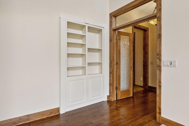 interior space featuring built in shelves and dark hardwood / wood-style flooring