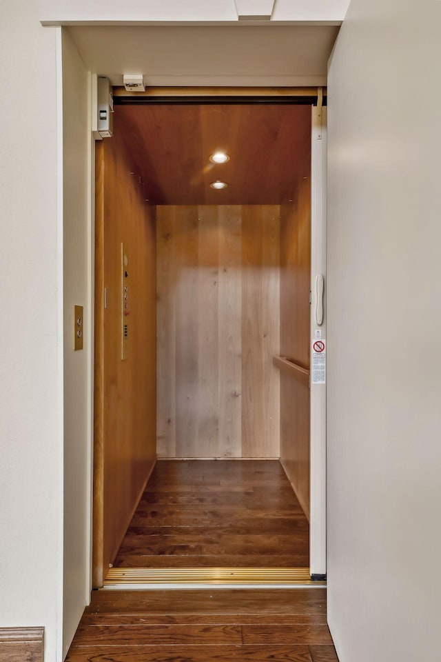 interior space with elevator and wood-type flooring