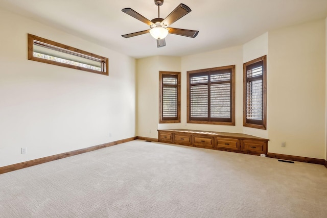 carpeted spare room featuring ceiling fan