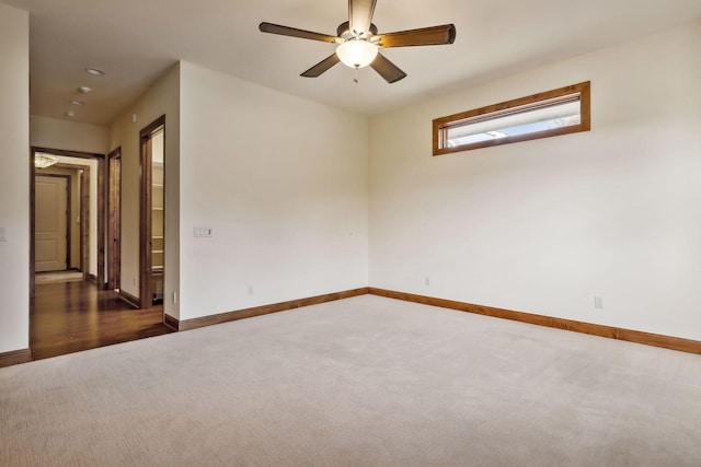 spare room featuring dark colored carpet and ceiling fan