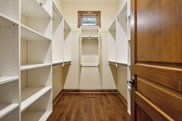 spacious closet featuring dark hardwood / wood-style flooring