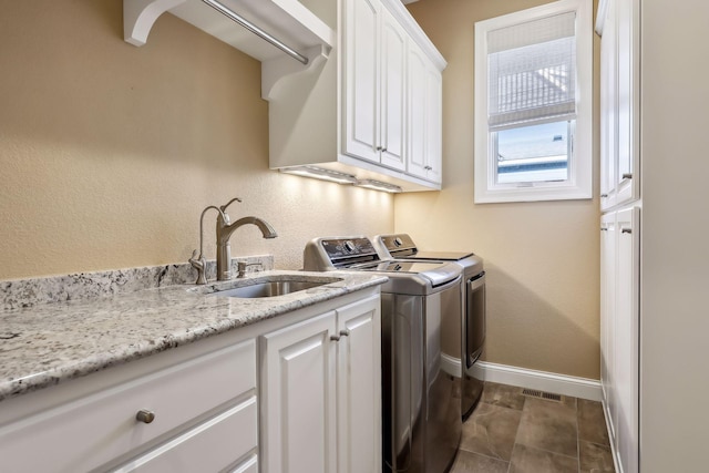 laundry area featuring sink, cabinets, and independent washer and dryer