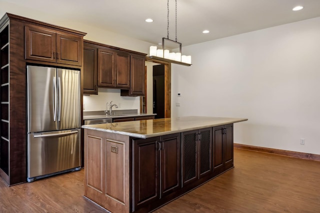 kitchen featuring stainless steel refrigerator, a kitchen island, dark brown cabinets, and light hardwood / wood-style flooring