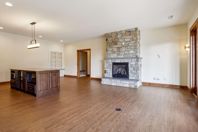 unfurnished living room featuring dark wood-type flooring and a fireplace