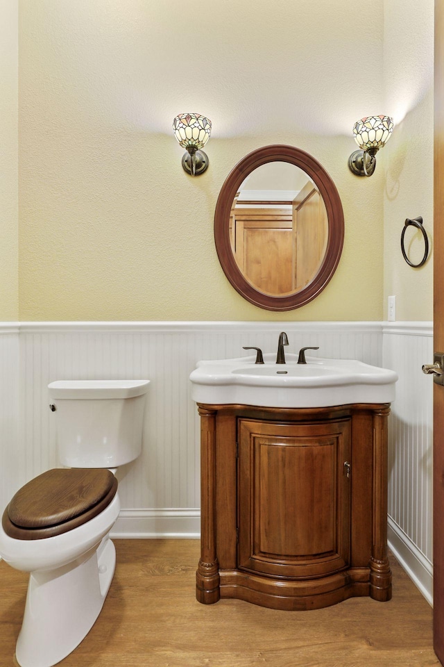 bathroom with hardwood / wood-style flooring, vanity, and toilet