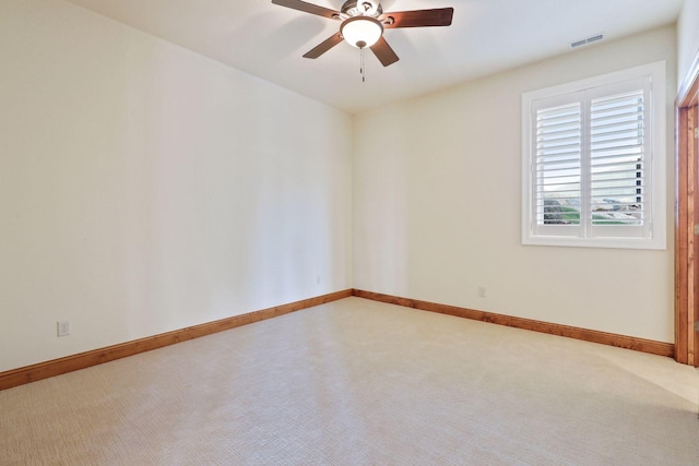 empty room featuring ceiling fan and carpet