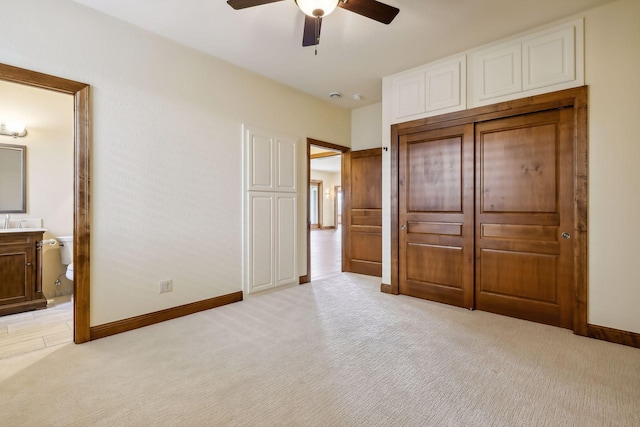 unfurnished bedroom with ceiling fan, connected bathroom, and light carpet