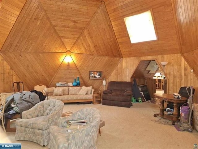 carpeted living area with wooden walls and vaulted ceiling