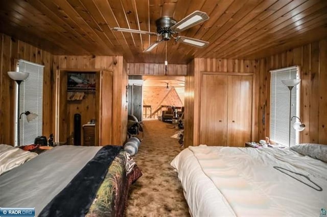 bedroom featuring multiple closets, wood ceiling, carpet flooring, and wood walls