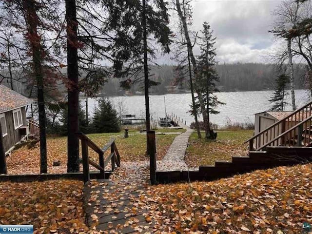 view of yard featuring a water view and stairway