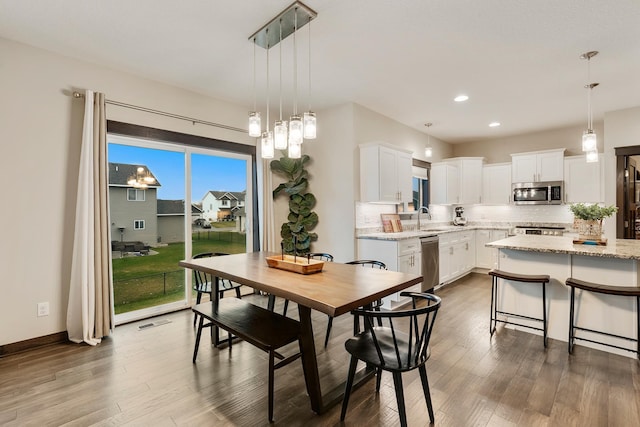 dining area with sink and hardwood / wood-style flooring