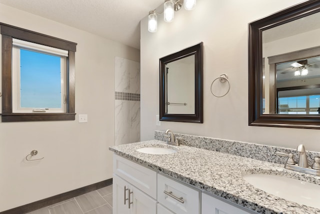 bathroom with ceiling fan, a textured ceiling, and vanity