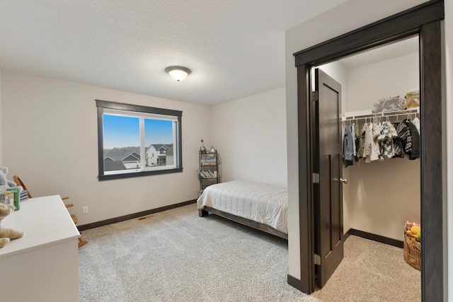 carpeted bedroom with a textured ceiling and a closet