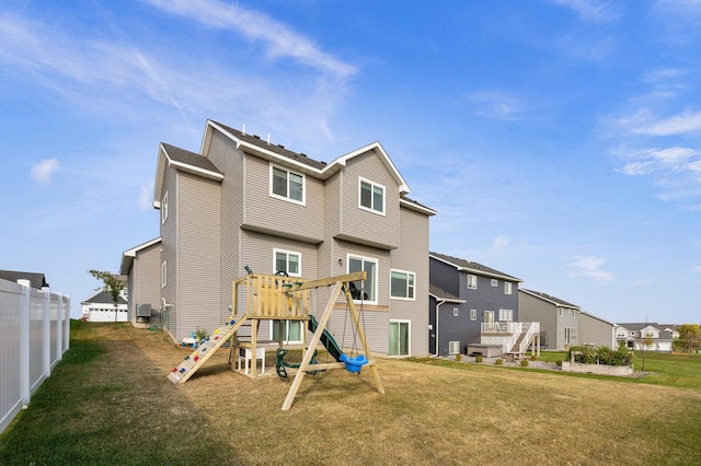 rear view of house with a lawn and a playground