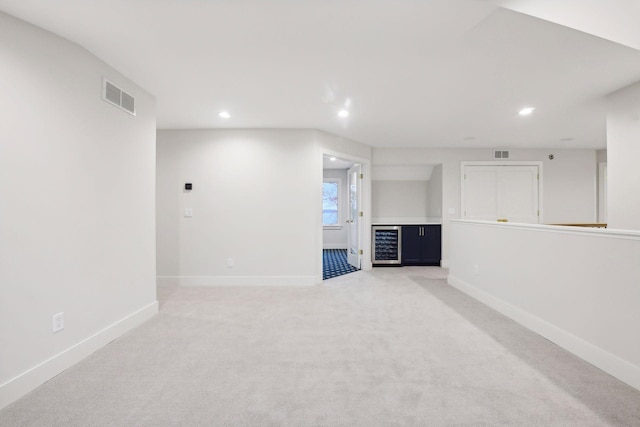 interior space with wine cooler and light colored carpet