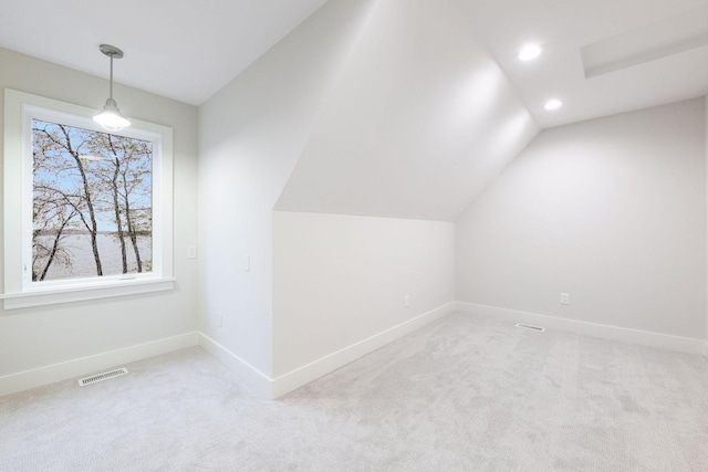 bonus room with light colored carpet and lofted ceiling