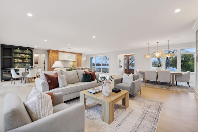 living room featuring a chandelier, plenty of natural light, and light wood-type flooring